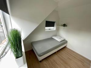 海滨诺德韦克T-Rots, prachtig zomerhuis的小房间设有床铺和电视