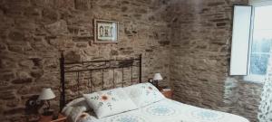 蒙多涅多A Casa das Augas的一间卧室设有一张床和石墙