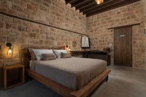 罗德镇Ancient Knights Luxury Suites的一间卧室设有一张床和砖墙
