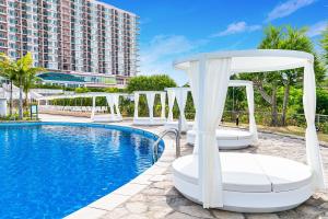 名户Oriental Hotel Okinawa Resort & Spa的酒店游泳池设有椅子,酒店