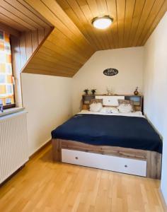 克尼特尔费尔德Ferienhaus Silke的一间卧室设有一张带木制天花板的大床