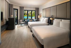 南芭堤雅InterContinental Pattaya Resort, an IHG Hotel的酒店客房设有两张床和休息区。