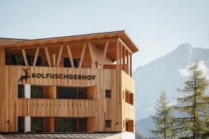 科尔福索Kolfuschgerhof Mountain Resort的建筑的侧面有标志
