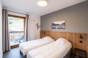奥瑞斯Vacancéole - Les Ecrins d'Auris的一间带两张床的卧室和一个阳台