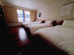 东京客房旅馆的窗户房间里一排三张床