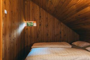 卢瑟Villa Šumik- Peaceful Hideaway的木制客房的一张床位,设有窗户
