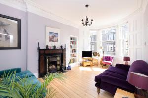 爱丁堡JOIVY Gorgeous 1-bed flat with a shared garden的带沙发和壁炉的客厅
