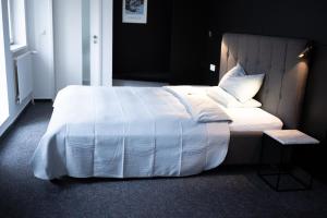 布伦瑞克Magni Boutique Hotel的卧室配有带白色棉被的床