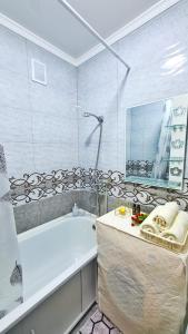 塔拉兹Абсолютно новая квартира класса ЛЮКС的带浴缸和盥洗盆的浴室