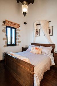 干尼亚Your-Villa, Villas in Crete的一间卧室配有一张带木制床头板的床和窗户。