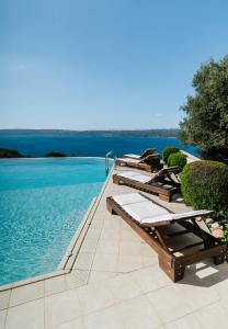 干尼亚Your-Villa, Villas in Crete的游泳池边的一排躺椅