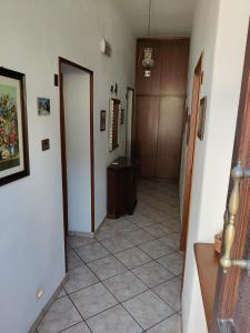 蒙特梅拉诺Affittacamere La Rondinella的走廊上设有门,铺有瓷砖地板