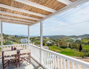 特里皮蒂Sofaki Milos的阳台享有房屋的景致,配有桌椅