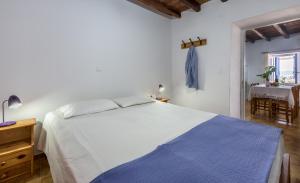 特里皮蒂Sofaki Milos的卧室配有一张白色的大床和一张桌子