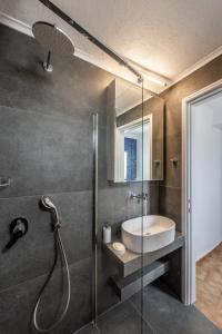 特里皮蒂Sofaki Milos的带淋浴、水槽和玻璃淋浴间的浴室