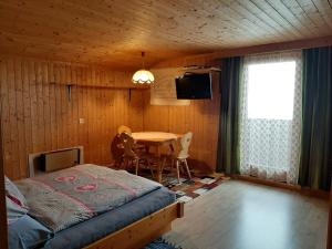 东蒂罗尔地区马特赖Ferienwohnung Kuenzer Alm的一间卧室配有一张床、一张桌子和一台电视