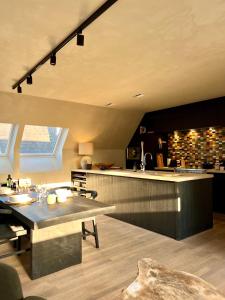 克诺克－海斯特luxe duplex met privé parking的厨房配有餐桌和柜台。