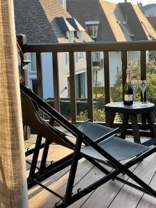 克诺克－海斯特luxe duplex met privé parking的阳台上的椅子和桌子以及一瓶葡萄酒