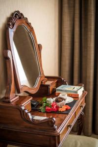 鲁塞多瑙河大酒店 的一张带镜子和鲜花的木制梳妆台