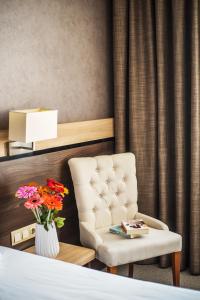 鲁塞多瑙河大酒店 的一间卧室配有椅子和花瓶