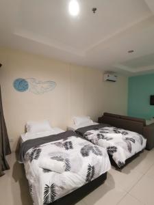 卢穆特Rustic one bedroom unit for 4 pax with Sea View by JoMy Homestay的两张睡床彼此相邻,位于一个房间里