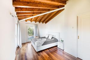 加尔多内-里维耶拉Poggio di Fasano 9 Apartment by Wonderful Italy的一间卧室设有一张床和木制天花板