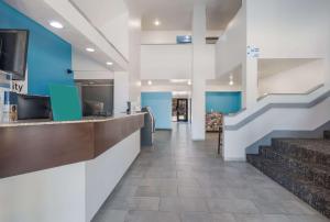 理查森Quality Inn & Suites Richardson-Dallas的医院的大厅,有蓝色的墙壁和楼梯