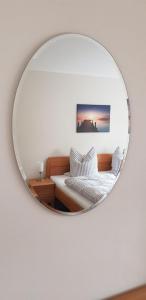 德累斯顿An den Elbwiesen的镜子反射着一间卧室,卧室配有一张床和一张沙发