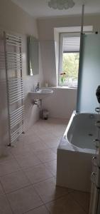 德累斯顿An den Elbwiesen的白色的浴室设有浴缸和水槽。