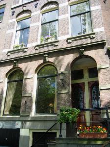 阿姆斯特丹Top-notch apartment along canal in historic centre的砖砌的建筑,前面有窗户和鲜花