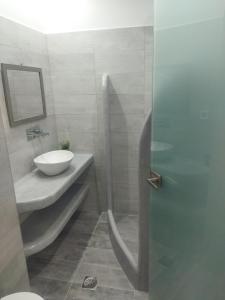 卡马利Ira Apartments的一间带水槽和玻璃淋浴间的浴室