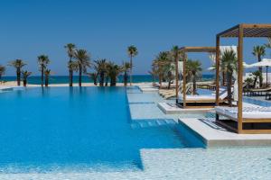 苏塞贾滋图尔哈勒夫酒店的棕榈树海滩旁的大型游泳池