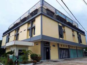 索龙RedDoorz near Dermaga Pelabuhan Rakyat的街道边的黄色和蓝色建筑