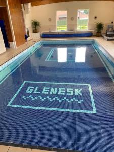 Edzell格兰纳斯克酒店的游泳池铺有蓝色和白色的瓷砖地板。