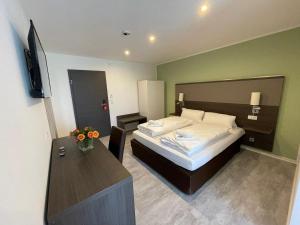梅肯博伊伦维森塔尔酒店的一间卧室配有一张带书桌和电视的床。