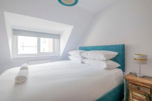 布莱顿霍夫3-bedroom apartment in the heart of Brighton's Lanes的白色的床、白色枕头和窗户