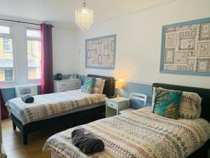 南安普敦Circle Guest House Bed Only的一间卧室配有两张床和吊灯。