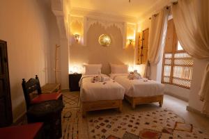 马拉喀什Riad El Habib的一间卧室设有两张床和窗户。