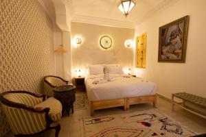 马拉喀什Riad El Habib的卧室配有白色的床和2把椅子