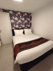 斯帕Studio de Spa的一间卧室配有一张大床和花卉床头板