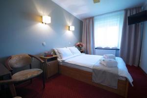 Zajazd Trzy Dęby的酒店的客房 - 带一张床、椅子和窗户