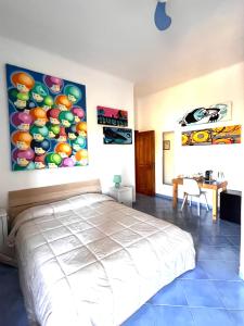 伊斯基亚B&B Villa Regine的卧室配有一张床,墙上挂有绘画作品