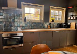 奥门Erf Hesse - holiday home的厨房配有灰色橱柜和台面