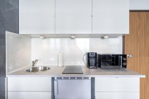 盖尔森基兴GelsenDesign II - Gemütliches Premium Apartment的厨房柜台设有水槽和微波炉