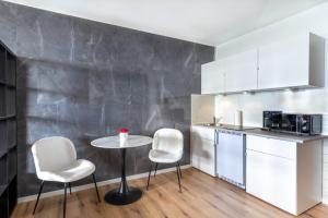 盖尔森基兴GelsenDesign II - Gemütliches Premium Apartment的一个带桌子和两把椅子的小厨房