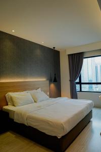 新山Suasana Lifestyle Suites by Keystone的一间卧室设有一张大床和大窗户