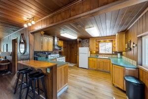 巴斯莱克Rustic Cabin的一个带木制橱柜的厨房和一个带酒吧凳的厨房岛