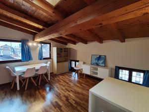 加尔达湖滨湖边公寓的客厅设有桌椅和木制天花板。