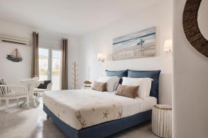 阿达玛斯Capetan Giorgantas的白色和蓝色的卧室配有床和椅子