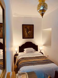 马拉喀什Riad Ajmal的一间卧室配有一张大床和一个吊灯。